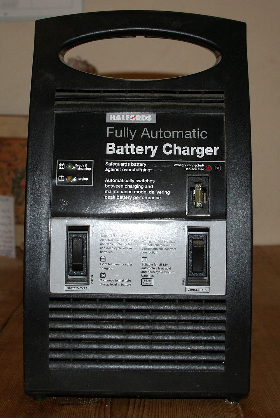 Automotive battery charger with a carrying handle
