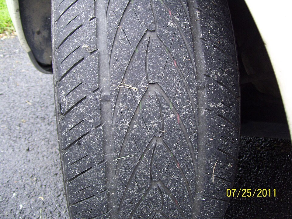 Close view across a car tire tread and shoulder